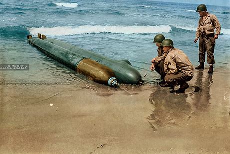 Lính lục quân Mỹ kiểm tra một tàu ngầm mini bị trôi dạt lên khu vực “đầu cầu” ở bãi biển Anzio, Italy. Tàu ngầm này được cải tạo từ một quả ngư lôi.