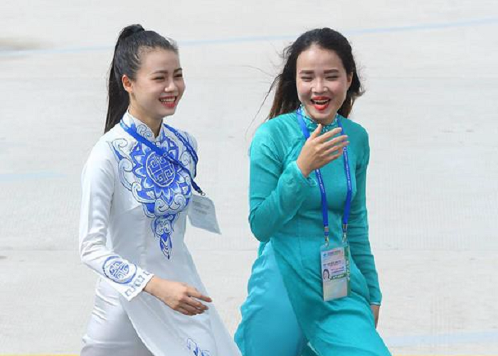 Trong trang phục áo dài trắng kèm theo họa tiết màu xanh dương nổi bật, cô gái tặng hoa cho Thủ tướng Lý Hiển Long nổi khiến  nhiều người ngây ngất vì vẻ đẹp trong sáng, nụ cười tươi và rất tự tin. (Ảnh: Trình Ca)