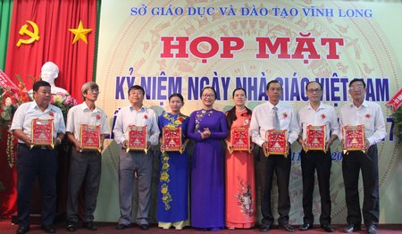 Tỉnh uỷ viên, Giám đốc Sở GD- ĐT- Nguyễn Thị Quyên Thanh (đứng giữa) trao danh hiệu “Gia đình Nhà giáo tiêu biểu” cho các nhà giáo.