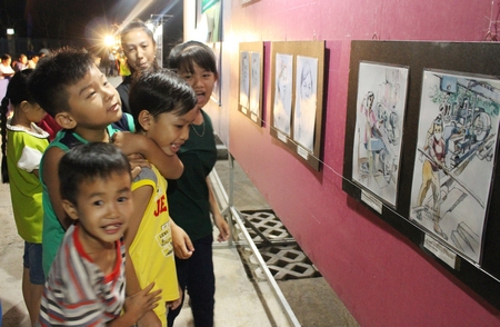 Trong năm, Phân hội mỹ thuật có nhiều triển lãm thực tế tại hải đảo và các xã nông thôn mới. Trong ảnh, các em thiếu nhi xem triển lãm tại Trung An- Vũng Liêm.