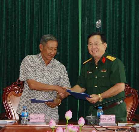 Đại tá Phùng Văn Mười- Chính ủy Bộ Chỉ huy Quân sự tỉnh (bên phải)- và Thiếu tướng Đoàn Văn Thắng- Chủ tịch Hội Cựu chiến binh tỉnh- trao đổi biên bản ghi nhớ chương trình phối hợp.