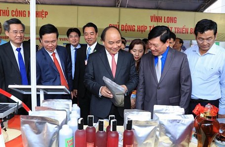 Thủ tướng Nguyễn Xuân Phúc (thứ 3, bên phải), lãnh đạo bộ, ngành Trung ương và Bí thư Tỉnh ủy Vĩnh Long Trần Văn Rón (thứ 2, bên phải) xem gian trưng bày sản phẩm tại Hội nghị Xúc tiến đầu tư. Ảnh: TTXVN