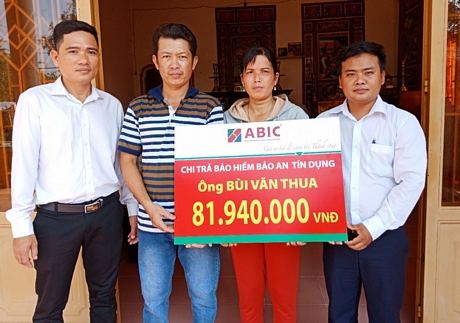 Ông Võ Văn Hoàng- đại diện ABIC (phải) và ông Nguyễn Trung Tín- đại diện Agribank TX Bình Minh (trái) trao biểu trưng cho gia đình khách hàng.