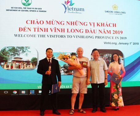 Ông Trần Văn Rón- Ủy viên BCH Trung ương Đảng, Bí thư Tỉnh ủy Vĩnh Long trao quà cho vị khách du lịch đầu tiên trong năm mới.