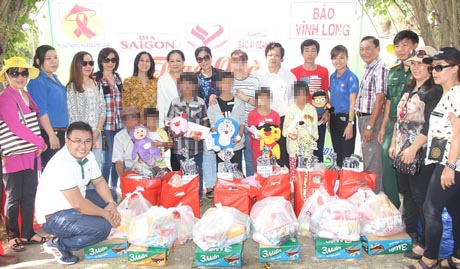 Ông Nguyễn Hữu Khánh- Tổng Biên tập Báo Vĩnh Long (người đứng thứ 7 từ phải sang) chụp ảnh lưu niệm cùng nhà tài trợ và các bé nhiễm HIV trong một đợt trao quà.