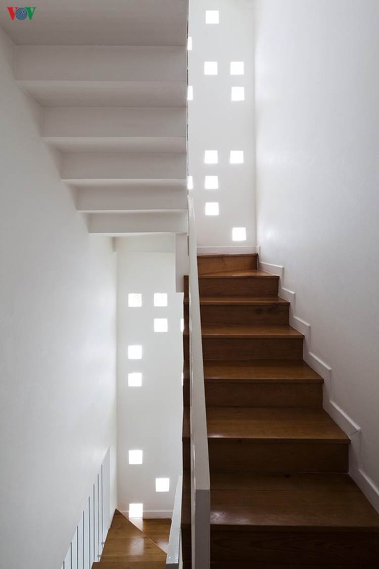 Cầu thang lên tầng được lấy sáng bằng những ô gạch kính đầy ngẫu hứng, đảm bảo ánh sáng mà vẫn kín đáo.