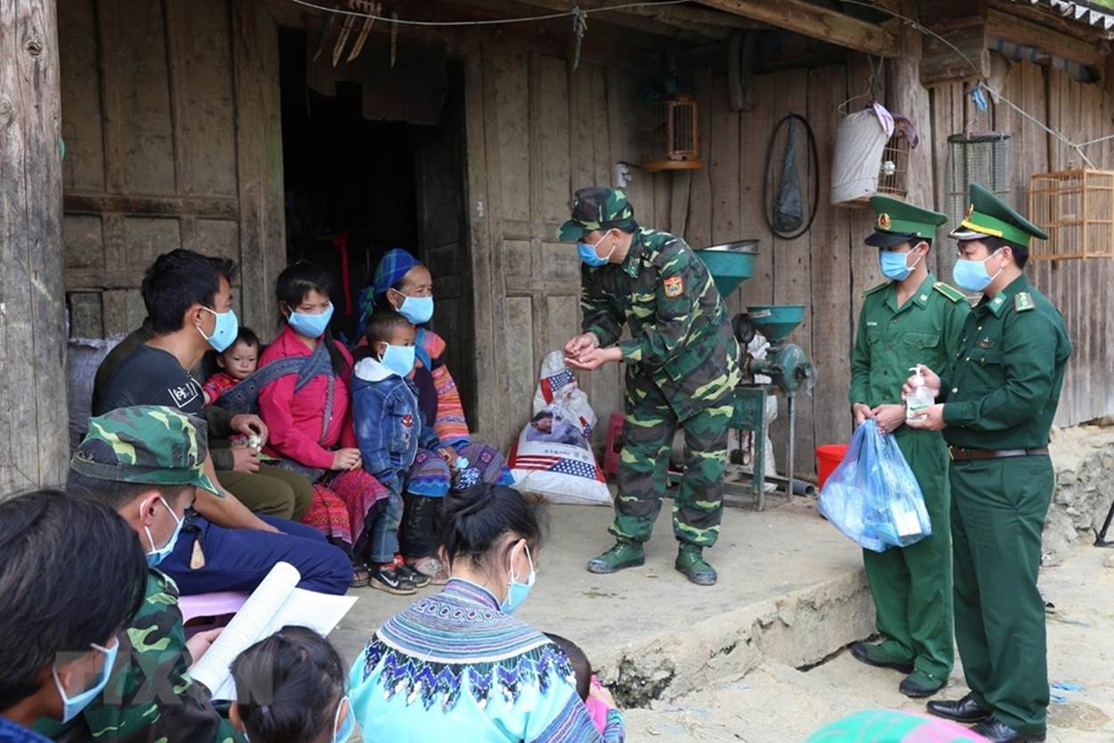  Cán bộ, chiến sỹ Đồn Biên phòng Pha Long, Bộ đội Biên phòng Lào Cai phát và hướng khử khuẩn phòng dịch cho người dân địa phương. (Ảnh: Dương Giang/TTXVN)