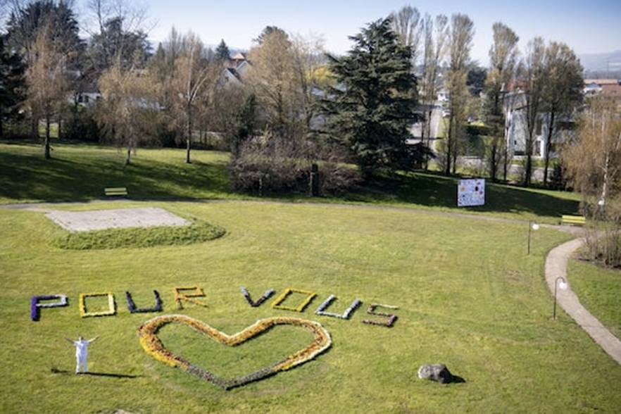  Thông điệp tri ân y bác sĩ trong vườn hoa Payerne, Thụy Sĩ. Ảnh: EPA