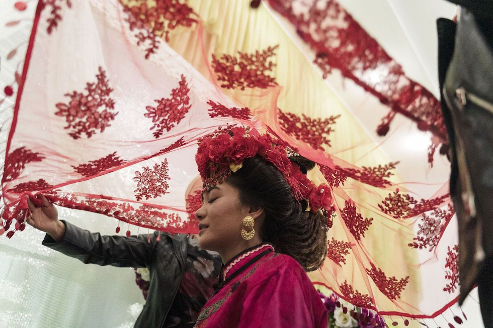 Yam G-Jun giành giải ở hạng mục ảnh Con người với bức ảnh chụp lễ cưới của người Dungan. Cô dâu 20 tuổi ở Milyanfan (Kyrgyzstan) được che đầu bằng một tấm màn đỏ trước khi rời khỏi nhà chú rể. Chiếc váy và nghi lễ cưới truyền thống người Dungan tại Kyrgyzstan chịu ảnh hưởng nhiều theo văn hóa cổ của Trung Quốc.
