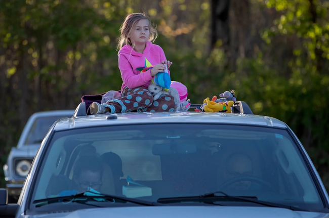  Một cô bé ngồi trên nóc xe ô tô gia đình tại rạp chiếu phim ngoài trời ở bang Georgia (Mỹ). Rạp chiếu phim này chỉ hạn chế 70 xe ô tô mỗi lần chiếu. Ảnh: EPA