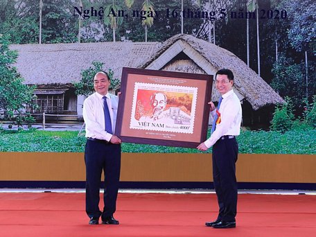 Bộ trưởng Bộ Thông tin và Truyền thông Nguyễn Mạnh Hùng tặng tem cho Thủ tướng Nguyễn Xuân Phúc. (Ảnh: Thống Nhất/TTXVN)