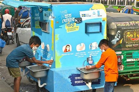 Trẻ em rửa tay phòng lây nhiễm COVID-19 tại trạm rửa tay di động ở Dhaka, Bangladesh, ngày 21/12/2020. Ảnh: THX/ TTXVN