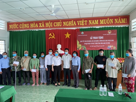 Đại diện lãnh đạo Sở Lao động- Thương binh và Xã hội, Quỹ Đầu tư phát triển tỉnh Vĩnh Long và chính quyền xã Tân Thành trao tặng quà cho người dân.