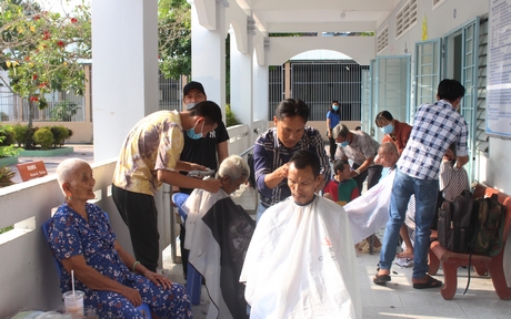 Các cụ già ở Trung tâm Công tác xã hội tỉnh được tình nguyện viên đến cắt tóc để đón tết