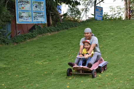 Du khách trải nghiệm với trò chơi trượt cỏ tại Khu du lịch sinh thái Bến Thành- Vinh Sang.