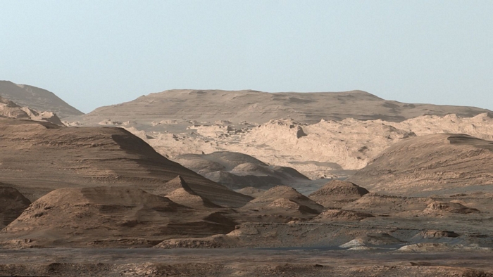 Hình ảnh về các vùng cao hơn của núi Sharp được tàu thám hiểm Curiosity của NASA chụp vào tháng 9-2015. Ở phía trước mặt là một rặng núi dài đầy hematit. Ngay phía xa hơn là một đồng bằng nhấp nhô giàu khoáng chất đất sét. Và xa hơn nữa là vô số ụ đất tròn chứa nhiều khoáng chất sunfat. Sự thay đổi về khoáng vật trong các lớp này cho thấy môi trường thay đổi ở sao Hỏa thời kỳ đầu, mặc dù tất cả đều liên quan đến việc tiếp xúc với nước hàng tỷ năm trước. Ảnh: NASA.