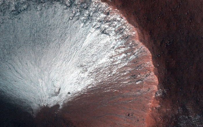 Máy ảnh HiRISE đã chụp miệng núi lửa có kích thước hàng km ở bán cầu nam của sao Hỏa vào tháng 6-2014. Miệng núi lửa này cho thấy băng giá phủ trên các sườn núi phía nam vào cuối mùa đông khi sao Hỏa đang vào mùa xuân. Ảnh: NASA.
