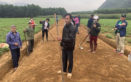 Ông Nguyễn Văn Liêm (giữa), người hiến đất và tham gia chương trình lao động đổi công của Oxfam, cùng dân làng thôn Cao Cảnh làm con đường đất phục vụ sản xuất ngày 24/3/2021 - Ảnh: QUỲNH TRUNG