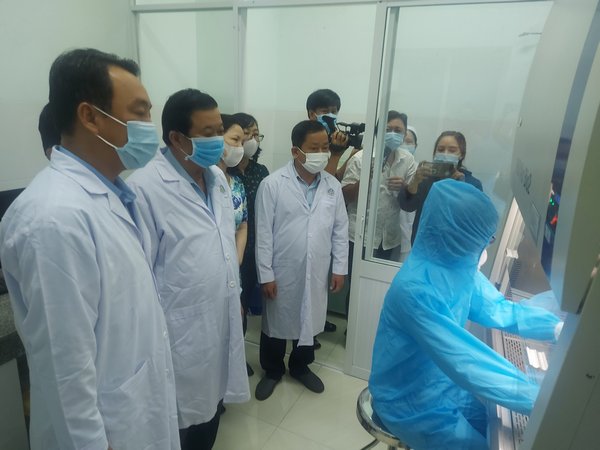 Phó Bí thư thường trực Tỉnh ủy Bùi Văn Nghiêm và Chủ tịch UBND tỉnh Lữ Quang Ngời xem hệ thống vận hành phòng xét nghiệm SARS-CoV-2 tại BVĐK tỉnh.