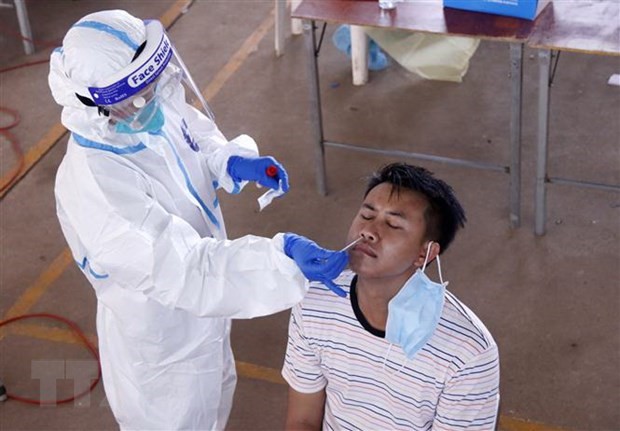 Bác sỹ đang lấy mẫu xét nghiệm cho một người dân Vientiane tại một điểm xét nghiệm dã chiến. (Ảnh: Phạm Kiên/TTXVN)
