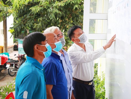 Người dân xã Thuận An xem tiểu sử người ứng cử được niêm yết tại trụ sở UBND xã.