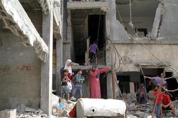 Người dân Palestine trở về bên những căn nhà đã bị phá hủy trong các cuộc không kích của máy bay Israel xuống thị trấn Beit Hanoun, Dải Gaza, khi lệnh ngừng bắn có hiệu lực, ngày 21/5. (Ảnh: THX/TTXVN)