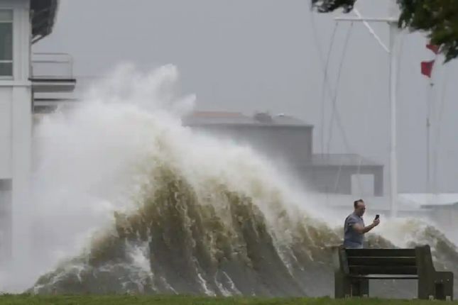 Một người chụp ảnh sóng lên cao dọc bờ hồ Pontchartrain tại New Orleans. Ảnh: AP.