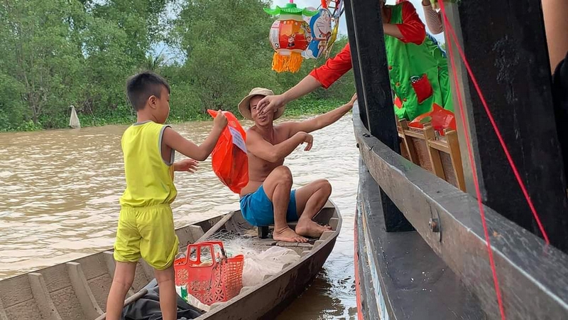 Anh Khương Nhựt Minh- nhà hảo tâm ngụ  TP Vĩnh Long đi ghe trao 100 phần quà trung thu cho trẻ em xã Đồng Phú (Long Hồ).