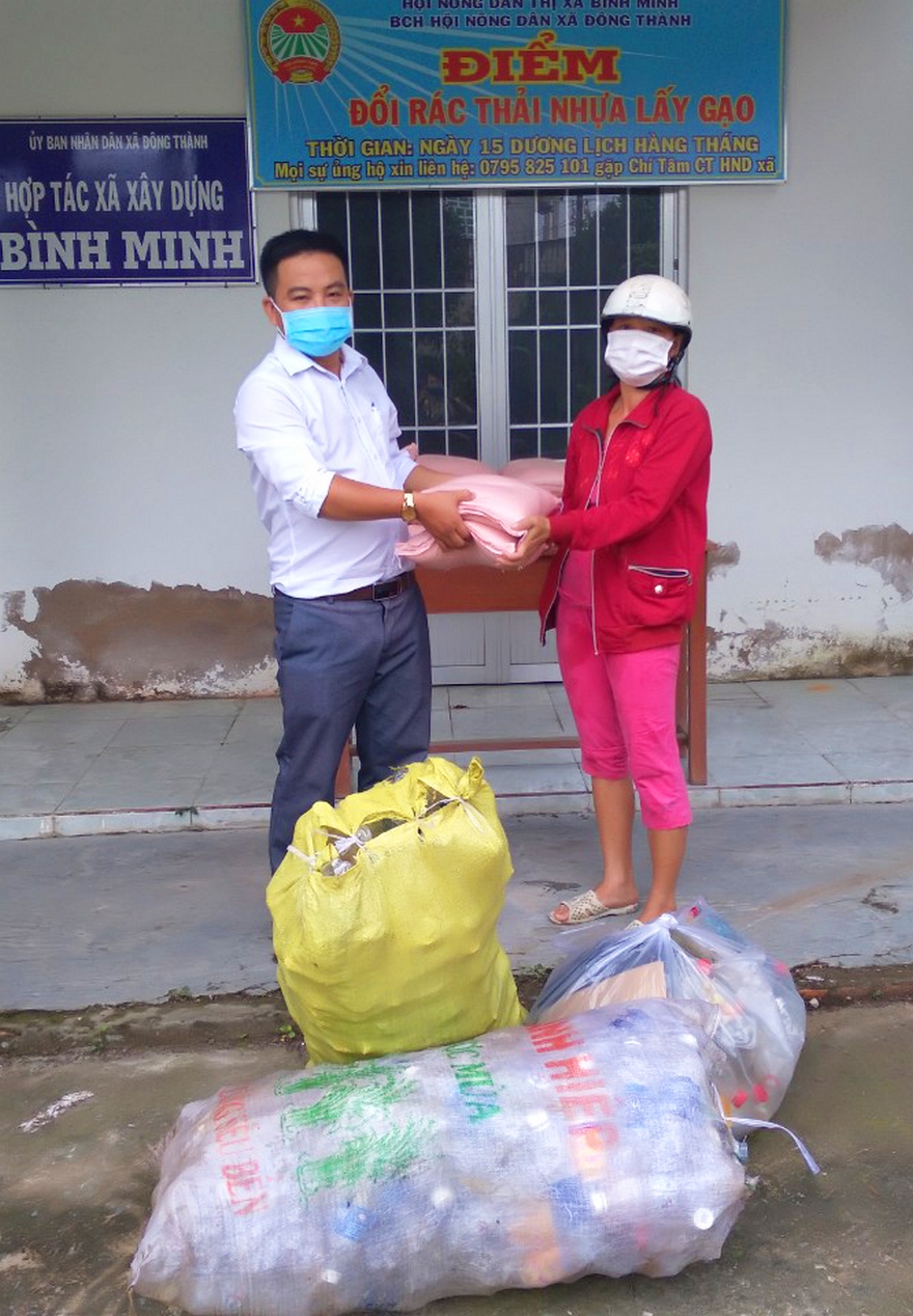 Ông Nguyễn Chí Tâm- Chủ tịch Hội Nông dân xã Đông Thành trao gạo cho người dân đem rác thải nhựa đến đổi.