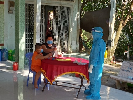Nhân viên Trạm Y tế xã Phú Đức đến thăm 2 mẹ con F0 điều trị bệnh tại nhà.