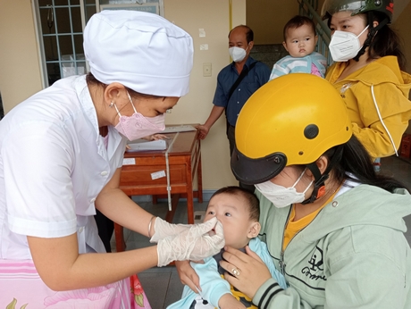 Phụ huynh đưa trẻ đến uống Vitamin A tại Trạm Y tế xã Thành Trung- Bình Tân vào sáng 1/6/2022.