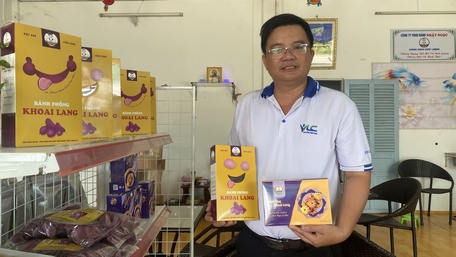 Anh Nguyễn Thanh Việt bên các sản phẩm bánh phồng khoai lang, bánh quy khoai lang của mình.