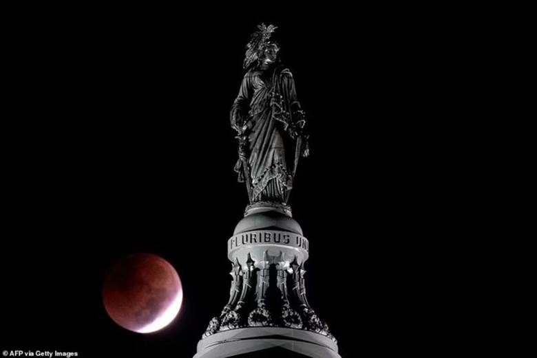 Hình ảnh nguyệt thực đằng sau bức tượng Tự do ở thủ đô Washington DC của Mỹ. Ảnh: AFP