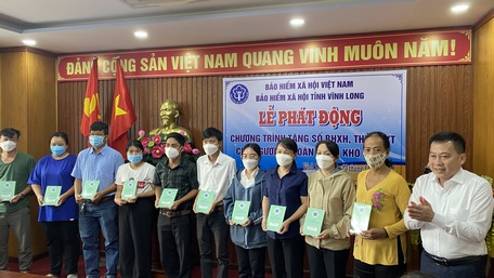 Giám đốc BHXH tỉnh - Phạm Minh Dương trao tặng sổ BHXH cho người có hoàn cảnh khó khăn.