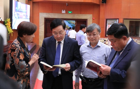 Phó Thủ tướng Thường trực Chính phủ Phạm Bình Minh xem ấn phẩm sách về Thủ tướng Võ Văn Kiệt. 