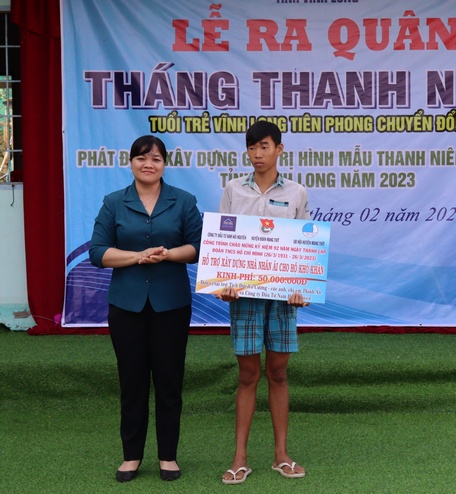 Đồng chí Nguyễn Huỳnh Thu - Tỉnh ủy viên, Bí thư Huyện ủy Mang Thít trao bảng tượng trưng hỗ trợ kinh phí xây nhà nhân ái