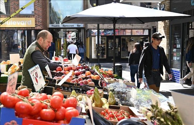 Người dân mua sắm tại một chợ ở London, Anh. Ảnh: AFP/TTXVN