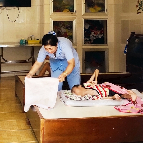 Nhân viên Lê Thị Tường Vi trong công việc hàng ngày ở khu trẻ khuyết tật.