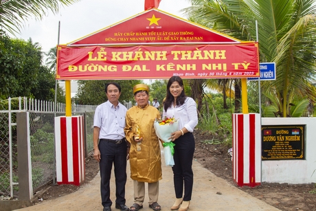 Bà Đặng Thị Bé Sáu- Phó Chủ tịch UBND huyện Trà Ôn tặng hoa cảm ơn ông Dương Văn Minh đã tài trợ xây dựng đường.
