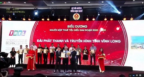 Bộ trưởng Bộ Tài chính Hồ Đức Phớc và Tổng cục trưởng Tổng cục Thuế Mai Xuân Thành trao chứng nhận biểu dương và tặng hoa cho đại diện lãnh đạo Đài Phát thanh và Truyền hình Vĩnh Long. Ảnh: THÙY LINH