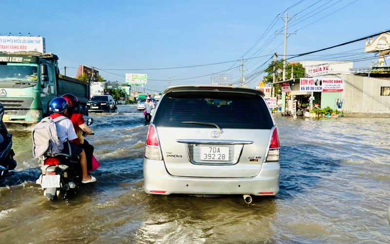 Một đoạn QL 1 qua TX Bình Minh ngập nặng, xe cộ ùn ứ hoặc phải nhích từng chút, một số xe máy chết máy.