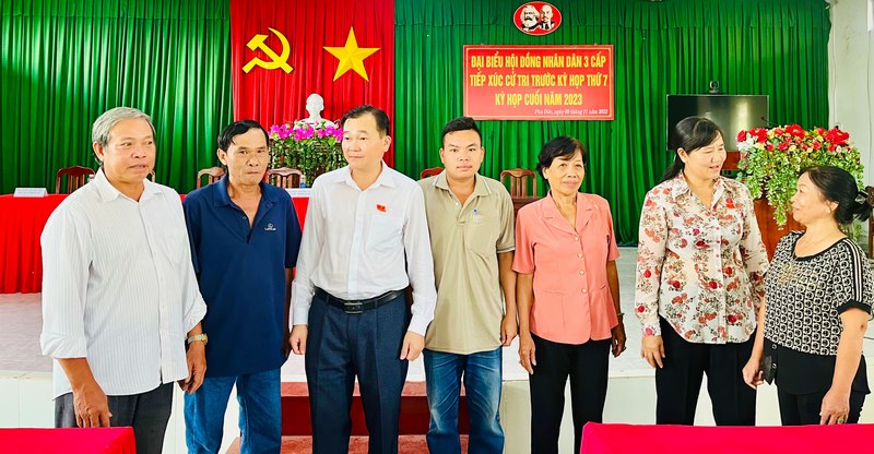 Đại biểu Nguyễn Minh Dũng- Phó Chủ tịch Thường trực HĐND tỉnh (thứ 3, bên trái) trao đổi với cử tri bên lề buổi tiếp xúc.