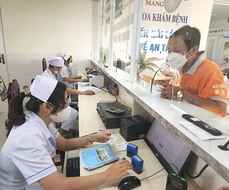 Nhân viên Trung tâm Y tế huyện Mang Thít tiếp nhận đăng ký khám, chữa bệnh cho người dân bằng thẻ BHYT, CCCD.
