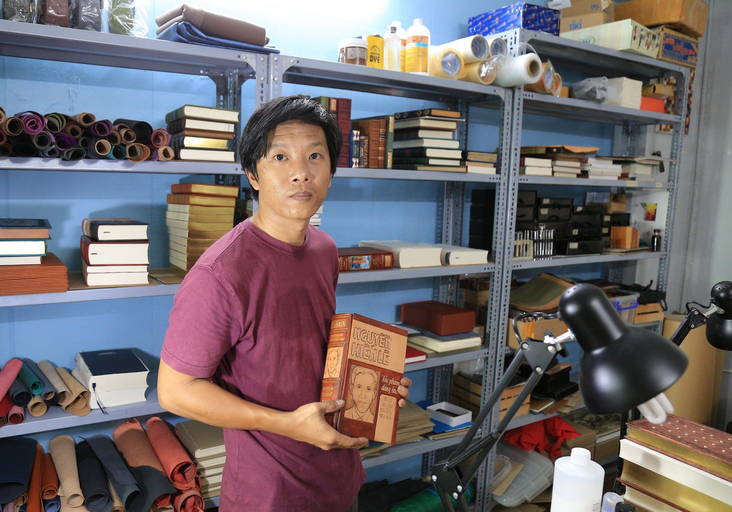 Anh Nguyễn Vũ Anh Hoan đang cầm trên tay là cuốn Nguyễn Hiến Lê cuộc đời và tác phẩm được một khách hàng yêu cầu làm bìa da.