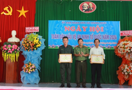 Phó Giám đốc Công an tỉnh Trần Quốc Phục tặng bằng khen của UBND tỉnh cho tập thể, cá nhân có thành tích xuất sắc trong tổ chức các hoạt động ngày hội TDBVANTQ.