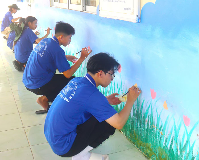Bạn trẻ tham gia “làm mới” bức tường trường học, góp phần tạo cảnh quan học đường xanh, sạch, đẹp.