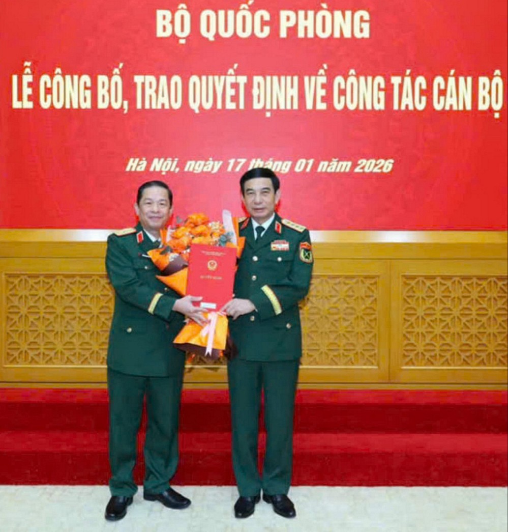  Đại tướng Phan Văn Giang – Ủy viên Bộ Chính trị, Bộ trưởng Bộ Quốc phòng trao quyết định và tặng hoa chúc mừng Thiếu tướng Trần Minh Trang.
