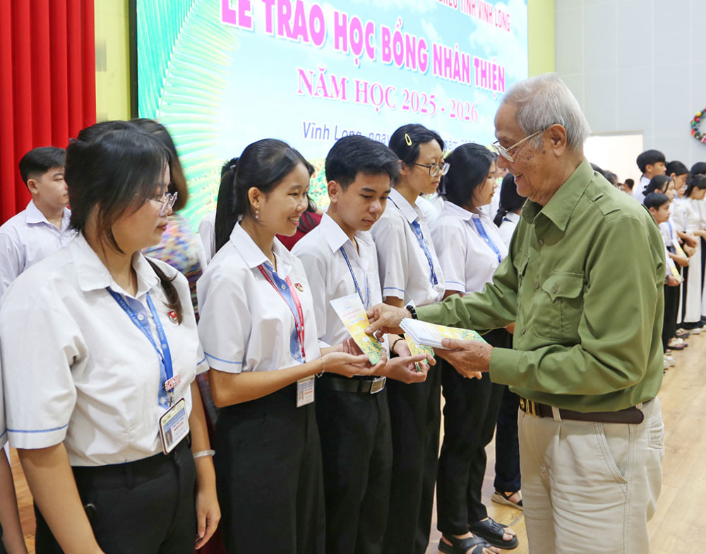 Ông Trần Công Ngữ- Chủ tịch Hội Bảo trợ bệnh nhân nghèo tỉnh, kiêm Giám đốc Hội đồng Quản lý Quỹ học bổng Nhân Thiện trao học bổng cho học sinh. Ảnh: NGỌC XOÀN