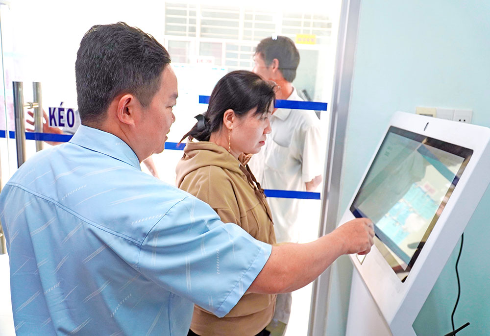 Cán bộ Trung tâm Phục vụ hành chính công xã Hương Mỹ hướng dẫn người dân lấy số thứ tự.