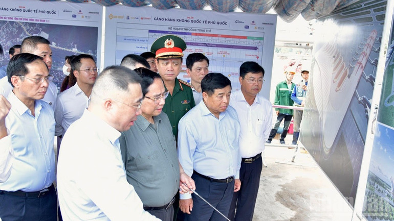 Thủ tướng Phạm Minh Chính nghe giới thiệu về tiến độ xây dựng Dự án đầu tư mở rộng Cảng hàng không quốc tế Phú Quốc. (Ảnh: THANH GIANG)